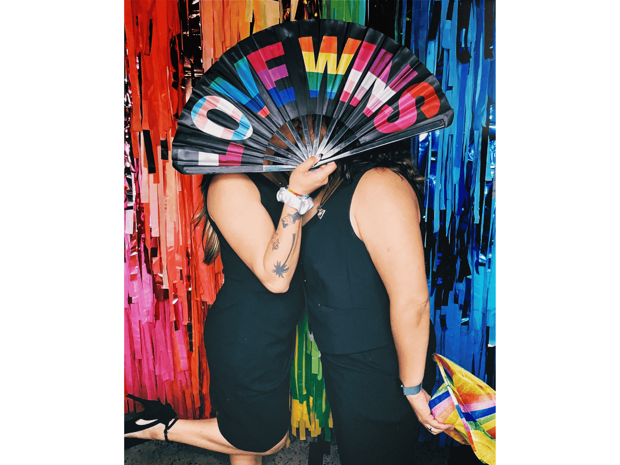 Couple Posing with LOVE WINS Fan in Front of Rainbow Fringe Backdrop at Phoenix Arizona PRIDE Photo Booth by MISGIF