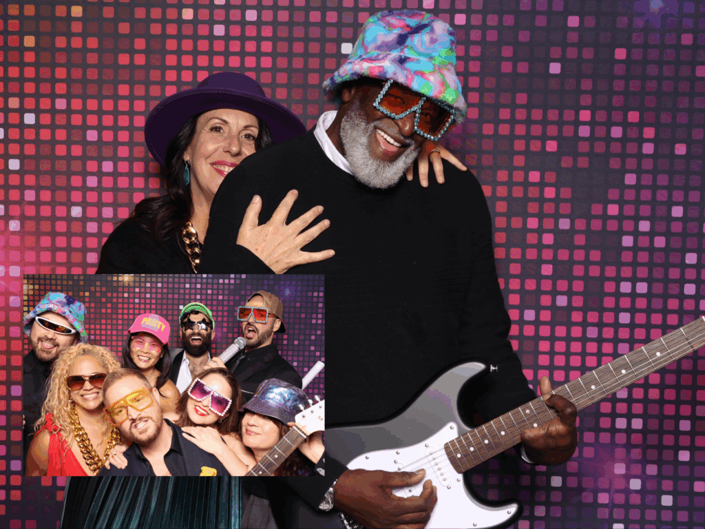 Corporate event guests in Phoenix Arizona Rockstar Photo Booth wearing colorful hats and glam rock sunglasses, posing with electric guitar and pixel-style backdrop as part of interactive Rock N Roll Photo Booth experience